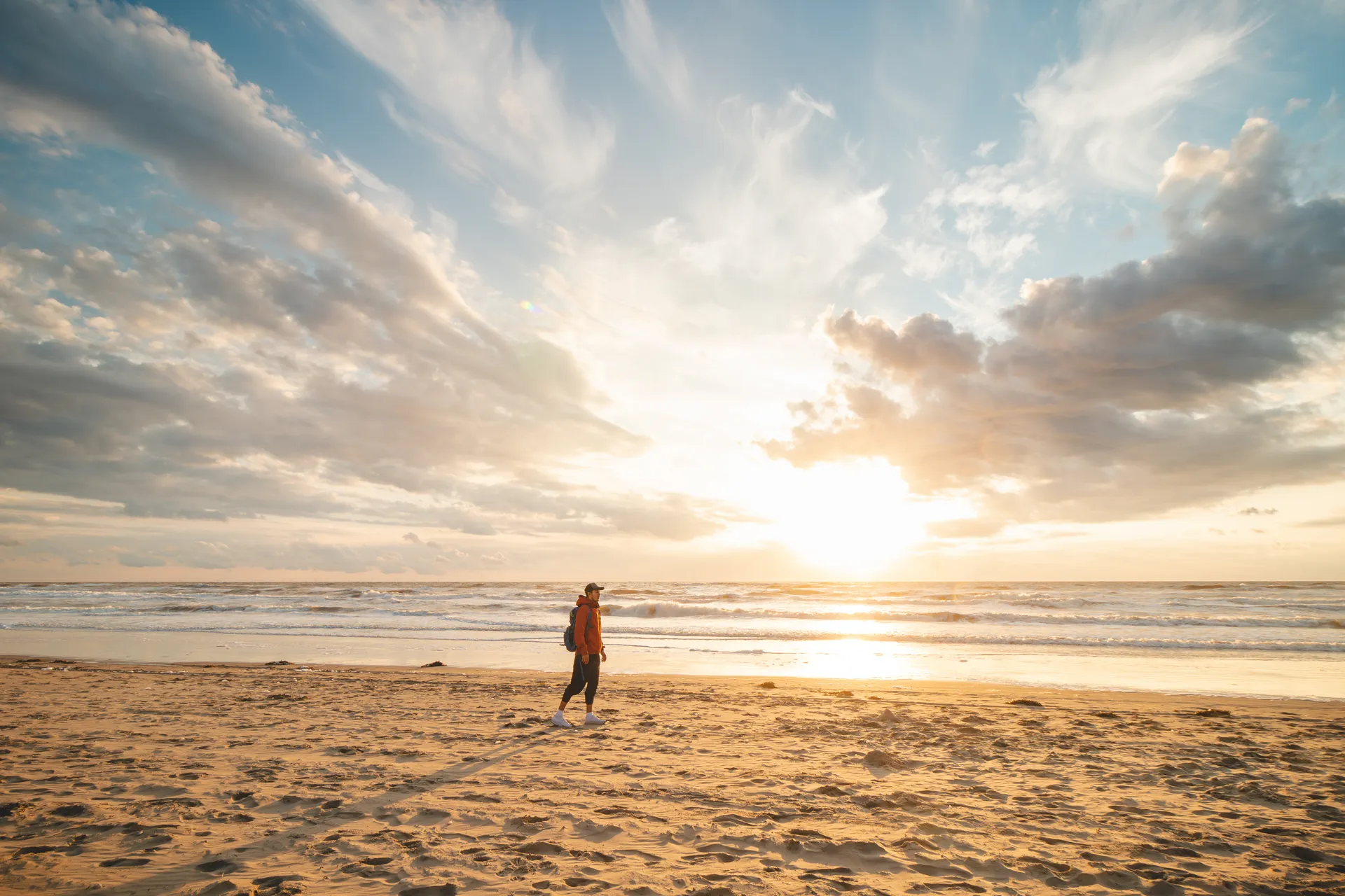 Guest walking along Zandvoort beach at sunset, less than a 10-minute walk from Ocean House Zandvoort
